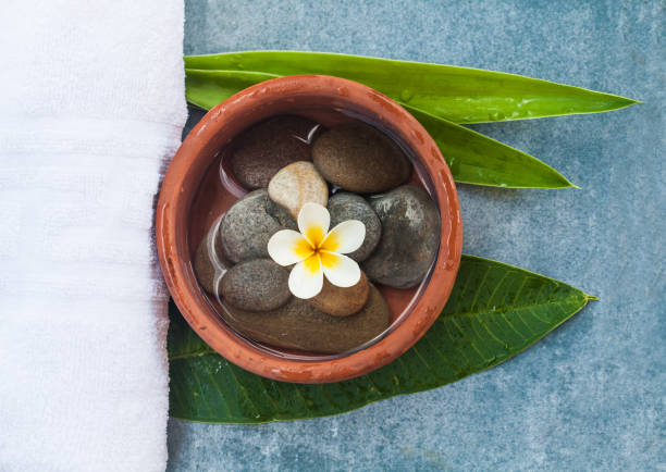 Top view of plate with spa objects and stones on marble background.