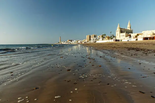 View of the beach Playa de Regla in Chipiona with church