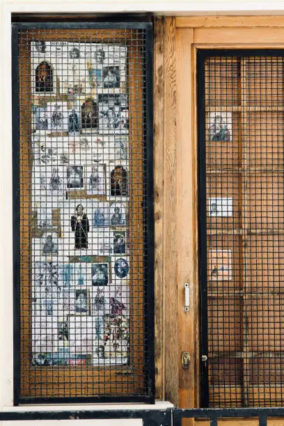 Alcamo, Italy - July 22, 2018: this is the house entrance of somebody who decided to decorate it with a large collection of holy pictures, depicting Christian Catholic Saints and divinities. All is protected by a cage