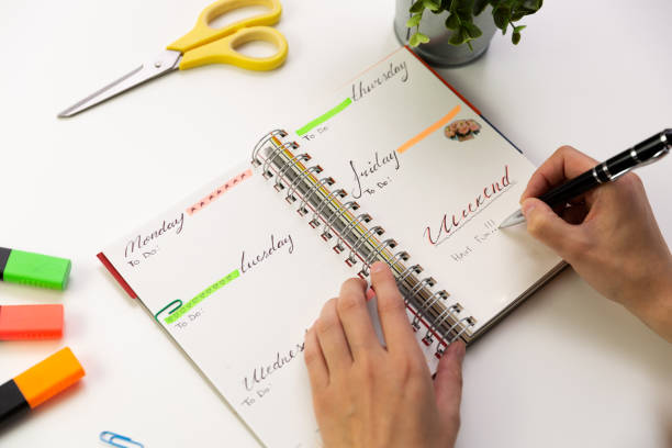 Woman's hands with pen writing in planner. Modern office desk. Working, writing concept