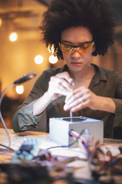 若い女性彼女のハイテク オフィスで基板をはんだ付け - women science service technology ストックフォトと画像