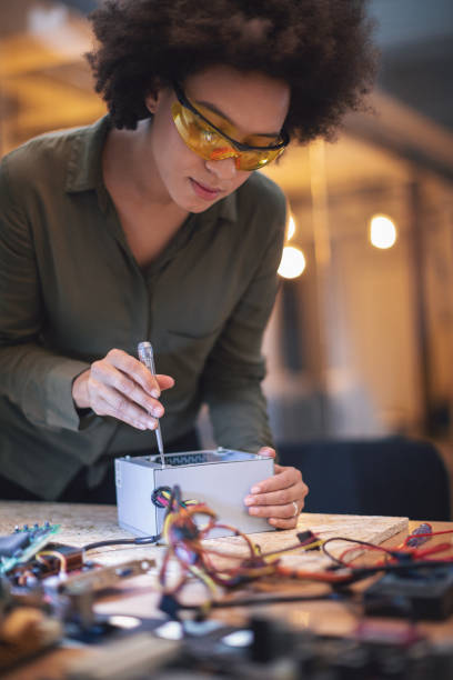 istock Young woman soldering a circuit boards in her tech office 1055881800
