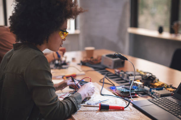 istock Young woman soldering a circuit boards in her tech office 1055881804