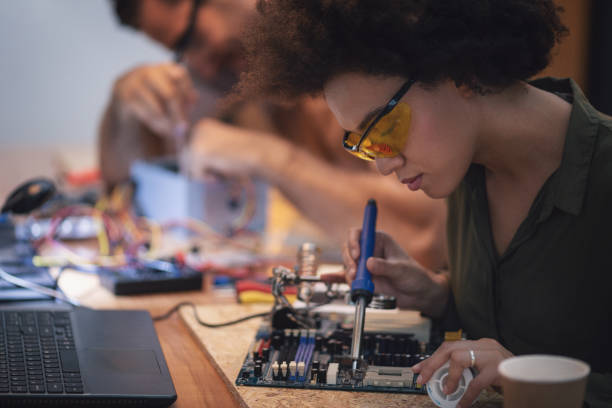istock Young woman soldering a circuit boards in her tech office 1055881818