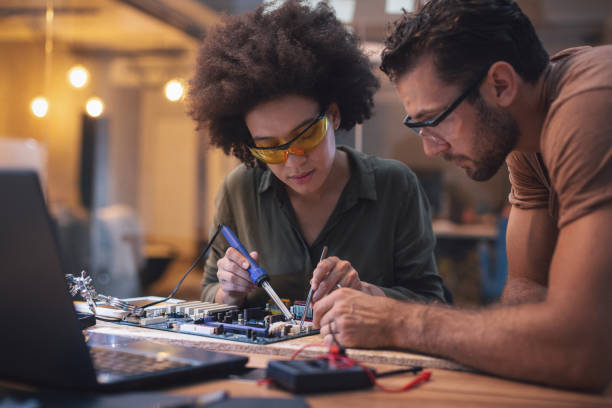 若い女性彼女のハイテク オフィスで基板をはんだ付け - women science service technology ストックフォトと画像