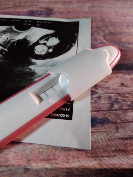 istock pregnancy test pack positive result at wooden table 1055881946