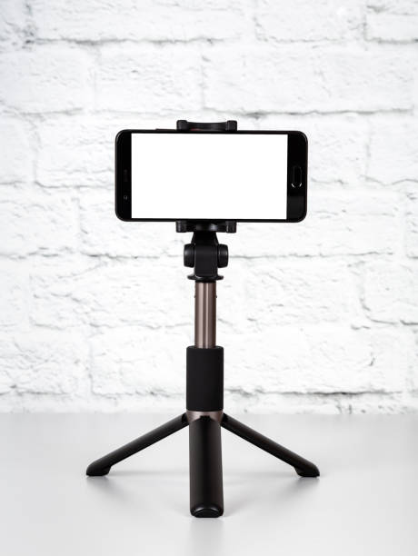 mockup with smartphone on a tripod with empty screen - tripod imagens e fotografias de stock