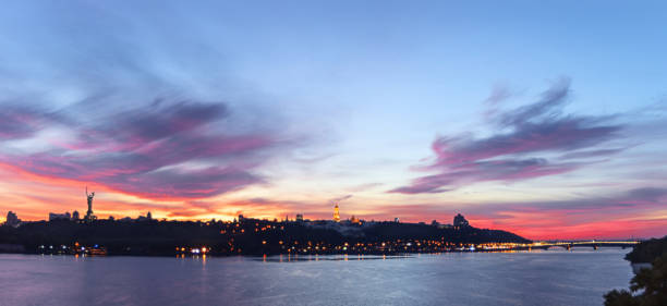 istock Multi colored Kiev panoramic view, sunset lit by magical colors, evening cityscape on the skyline of the monastery Lavra and Monument to Motherland. 1055884442