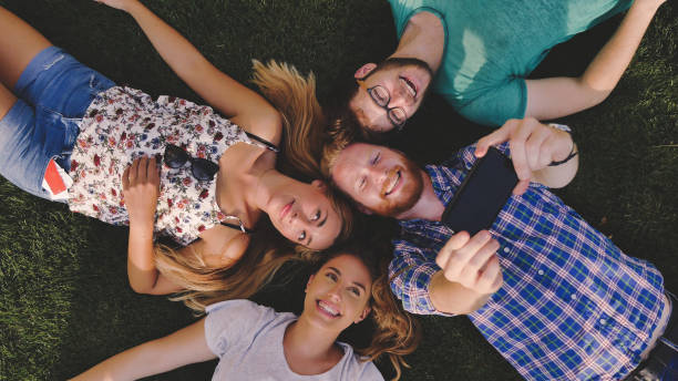 istock Careless young people having a laugh outdoors lying in grass 1055887564