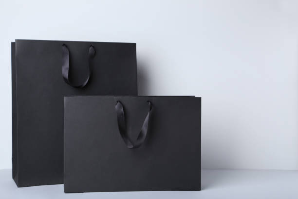 Black shopping bags on gray background stock photo