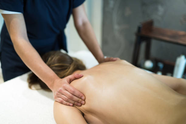 istock Masseur treating patient with therapeutic massage 1055889806