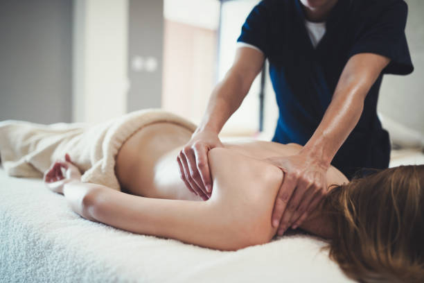 istock Therapist massaging patient at wellness spa 1055890550