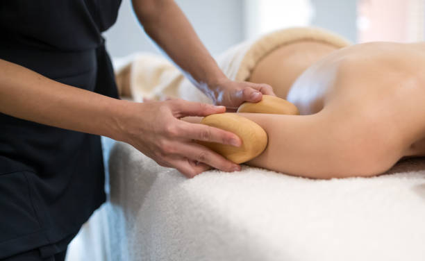 istock Masseur massaging masseuse at wellness resort 1055890678