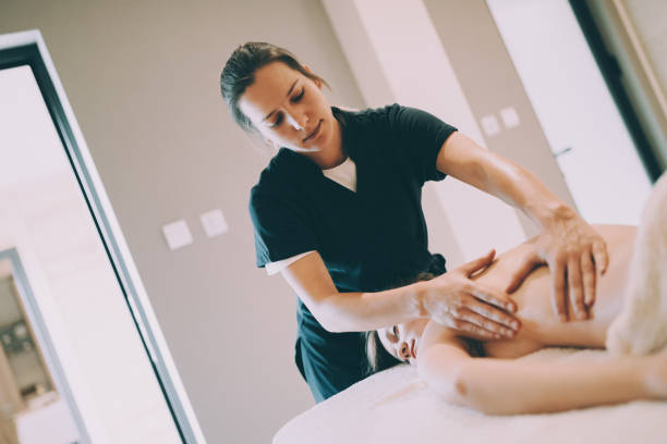 istock Masseur treating patient with therapeutic massage 1055890730
