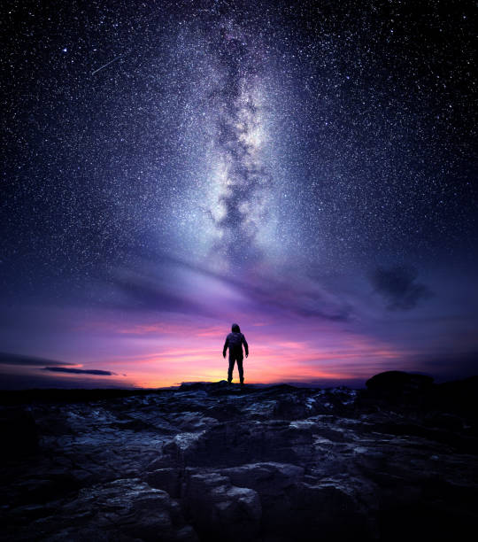 Milky Way Galaxy Night Landscape Night time long exposure landscape photography. A man standing in a high place looking up in wonder to the Milky Way galaxy, photo composite. milky way photos stock pictures, royalty-free photos & images
