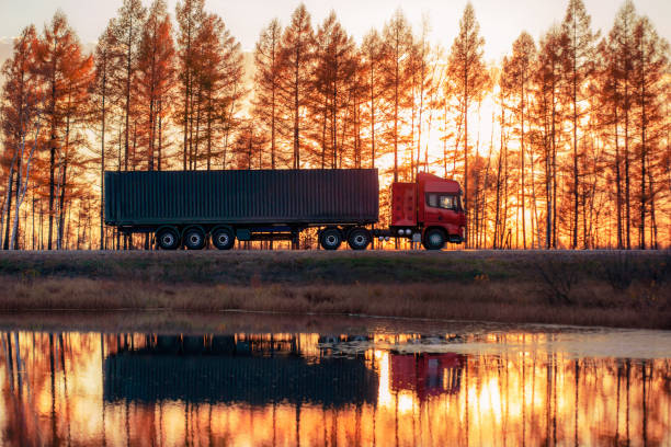 istock Red truck on a road at sunset 1055891354