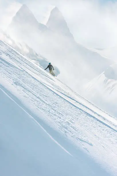 Snowboarder riding on a steep slope in a majestic winter landscape