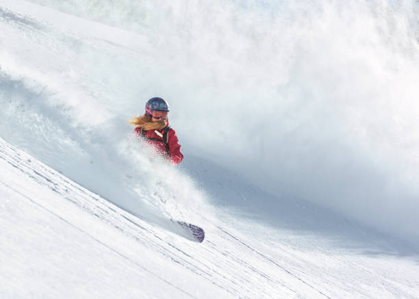 jinete de snowboard mujer cabalgando sobre nieve en polvo fresca - freeride fotografías e imágenes de stock