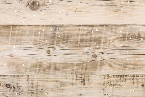 istock Small golden stars confetti on wooden background. 1055897708