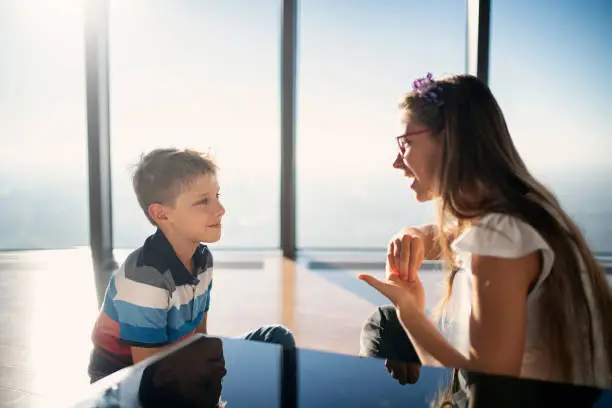 Photo of Brother and sister talking in sign language