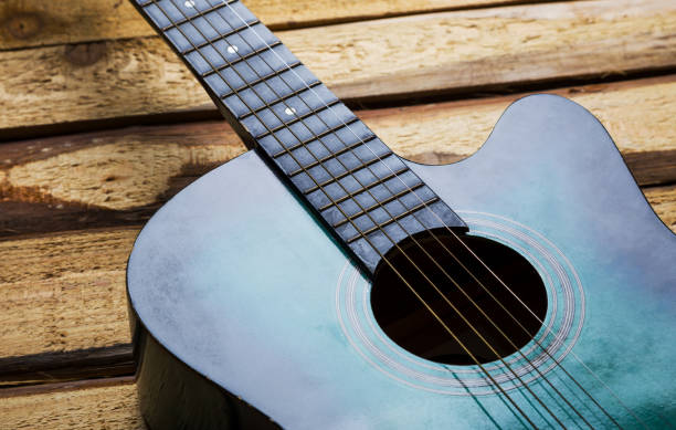 istock Guitar on wooden background 1055898372