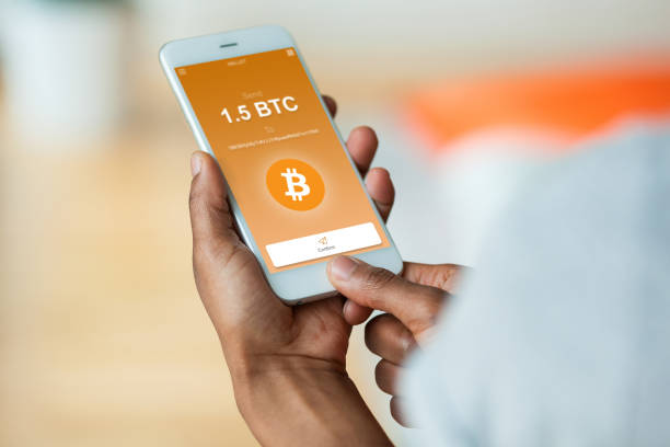 African american person sending a bitcoin btc crypto transaction using  mobile phone wallet - Black people stock photo