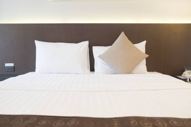 istock White bedding and two pillow in hotel room 1055902874