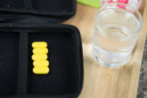 istock Close up yellow medicine (taking a pill and glass). 1055902880