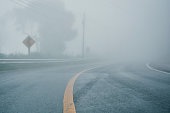 foggy rural asphalt highway perspective with white line, misty road, Road with traffic and heavy fog, bad weather driving