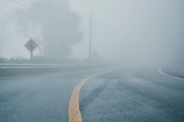 foggy rural asphalt highway perspective with white line, misty road, Road with traffic and heavy fog, bad weather driving foggy rural asphalt highway perspective with white line, misty road, Road with traffic and heavy fog, bad weather driving fog stock pictures, royalty-free photos & images