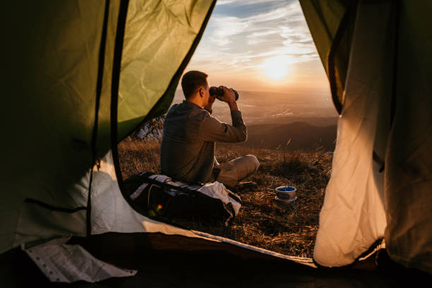 istock Man explorer with a tent at top of mountain 1055910726