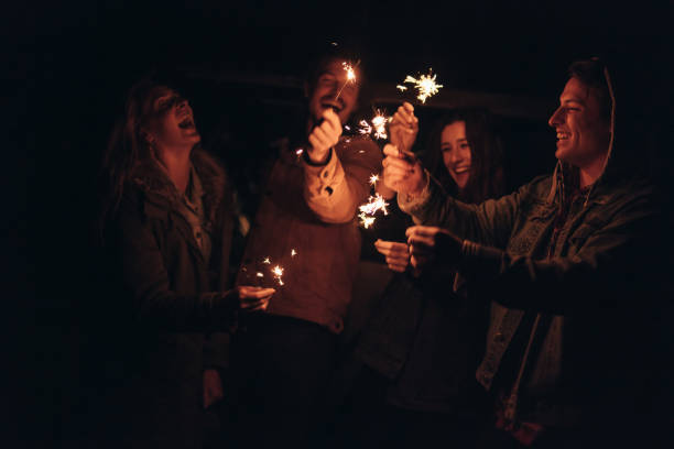 istock Group of friends lighting fire sparkles 1055914782