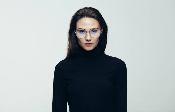 frau im schwarzen kleid, starrte auf kamera - staring black and white glasses human face stock-fotos und bilder