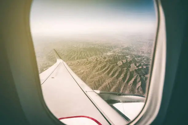 looking cloud sea through window of airplane