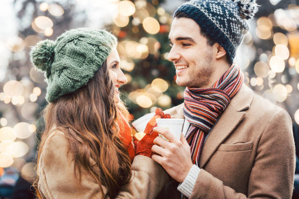 Woman and man drinking mulled wine on Christmas Market Woman and man drinking mulled wine on Christmas Market in front of tree punch drink stock pictures, royalty-free photos & images