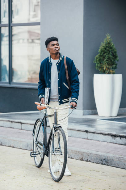 istock handsome african american freelancer with documents and bike 1055917706