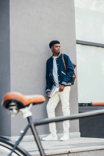 istock selective focus of handsome african american freelancer with documents and bicycle 1055917736