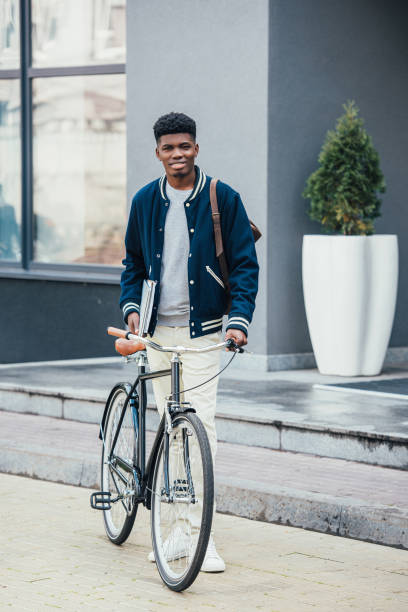 istock handsome african american freelancer with documents and bicycle 1055917790