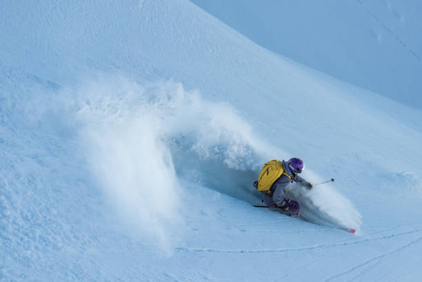 istock Female freeride skier making a turn on powder snow 1055919398