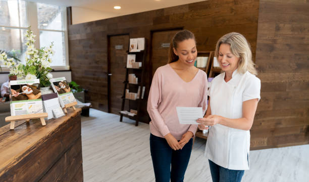 istock Spa manager showing a brochure to a happy customer 1055919950