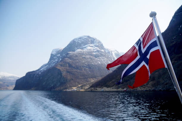 istock Norway Flag on sea and mountains background 1055920802