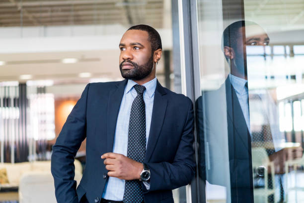 istock Thoughtful businessman leaning on glass at office 1055920944
