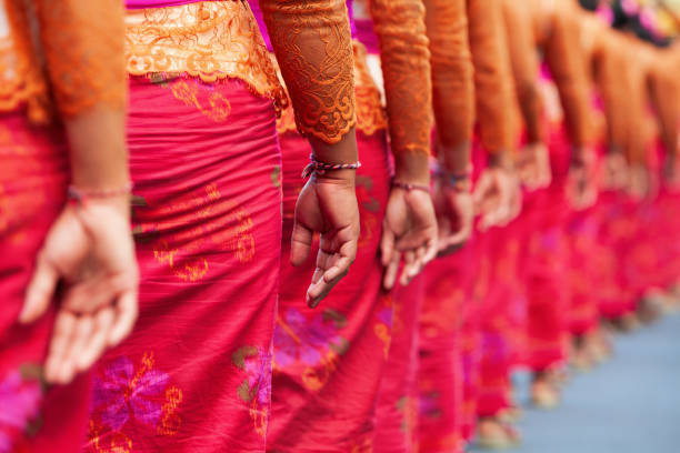 Group of beautiful Balinese women in costumes - sarong, carry offering for Hindu ceremony. Traditional dances, arts festivals, culture of Bali island and Indonesia people. Indonesian travel background