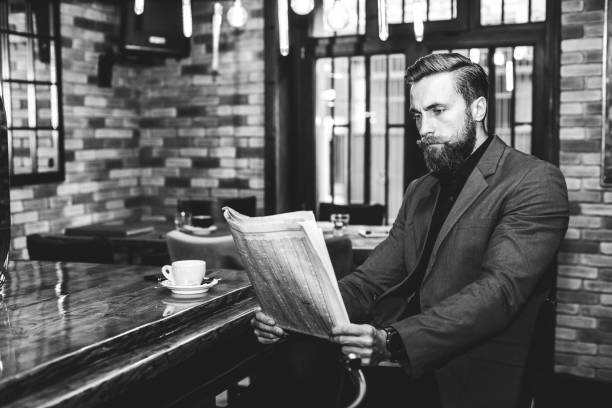 istock Young businessman reading a newspaper at the bar 1055923636