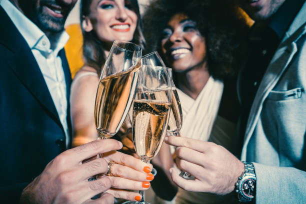 istock Men and women celebrating party while clinking glasses with sparkling wine 1055924044