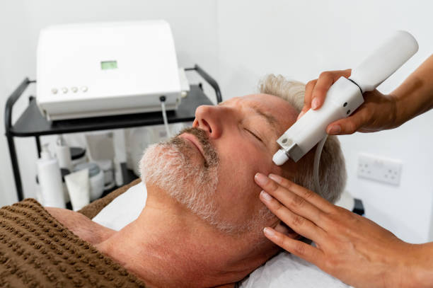 Man at the spa getting a facial laser treatment Handsome man at the spa getting a facial laser treatment - beauty concepts microdermabrasion stock pictures, royalty-free photos & images