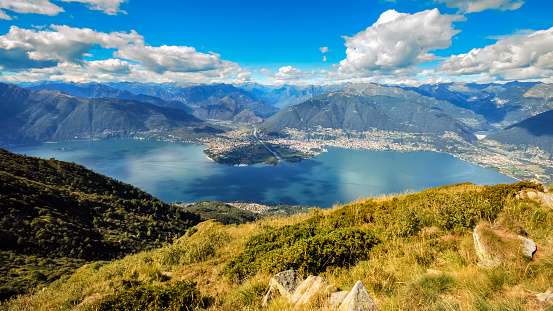 Looking across the Lake Locarno (Ticino, Switzerland) from a mountain peak near the village of Indemini on a summer day. The cities of Ascona and Locarno are lying next to the lake.