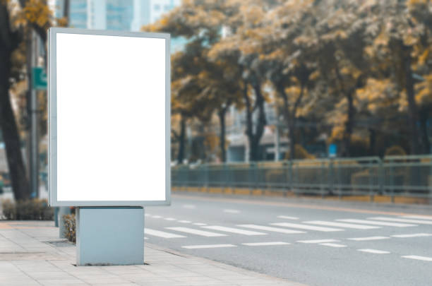 istock big blank billboard white LED screen vertical outstanding in the city on pathway side the road traffic for display advertisement text template promotion new brand at outdoor with green tree. 1055935744