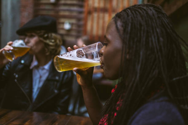 Two Women drinking beer in a cafe,side view