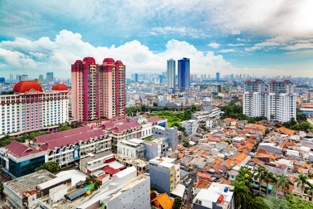 Central Jakarta aerial skyline under moody cloudy sky Central Jakarta skyline under moody cloudy sky, featuring the contrast between modest housing and large apartment towers and hotels. jakarta slums stock pictures, royalty-free photos & images